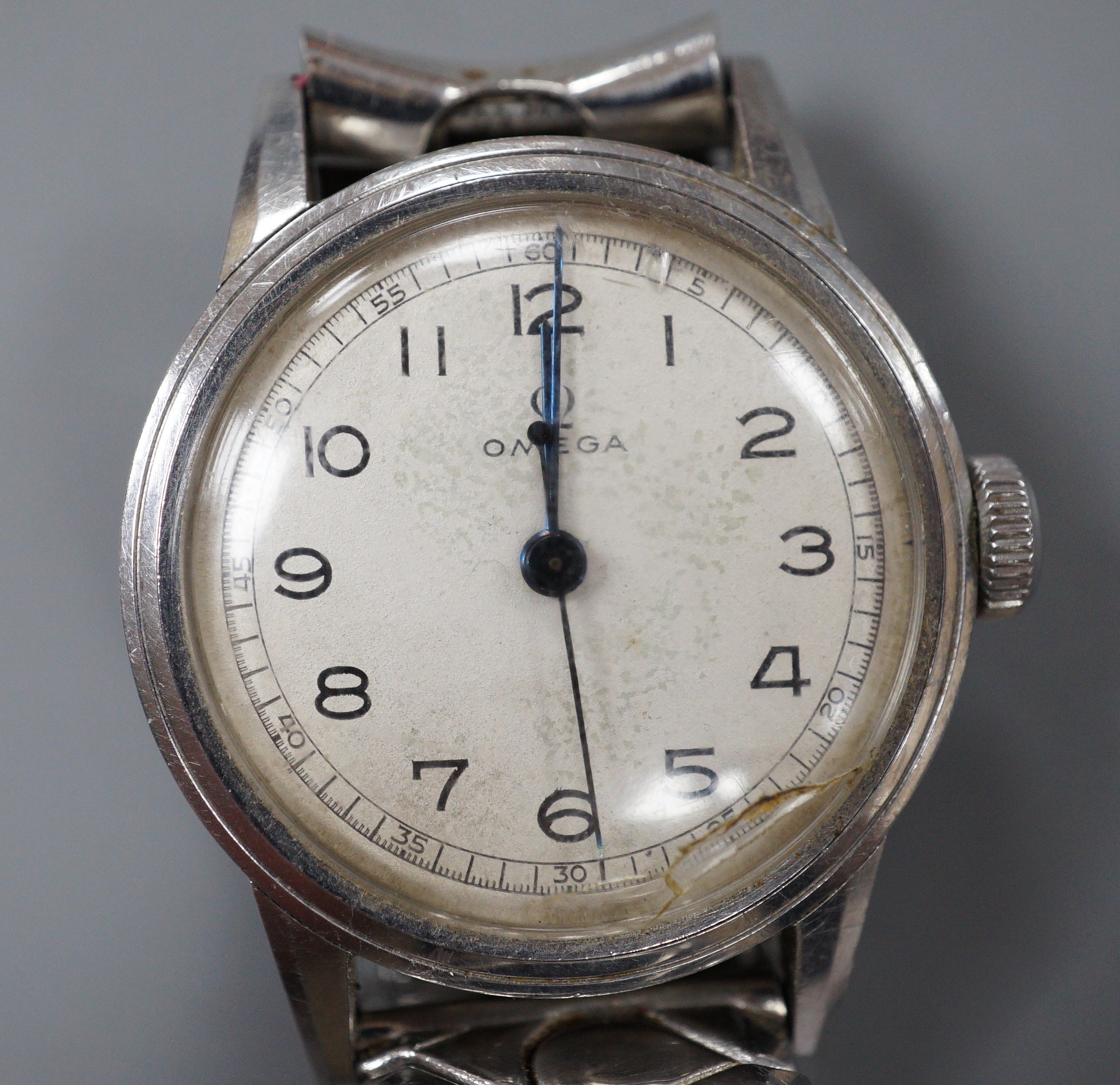 A gentleman's early 1940's mid size stainless steel Omega manual wind wrist watch, with Arabic dial, case diameter 31mm, on associated flexible bracelet, no box or papers (dial cover cracked).